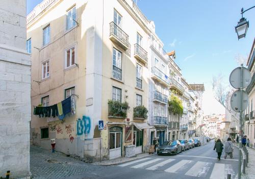 a building on a street with people walking down the street at Spacious, Bright and Newly Renovated 2 Bedroom Apartment, Lisbon Historical Center, Madragoa in Lisbon