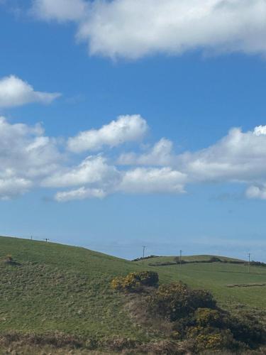 a green field with a blue sky and clouds at Luxury 4 bedroom lodge in Doolin in Doolin