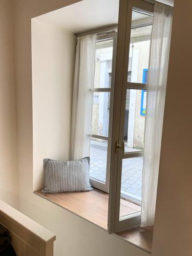 une fenêtre avec un oreiller assise sur un rebord de fenêtre dans l'établissement Studio en hyper centre, à La Rochelle