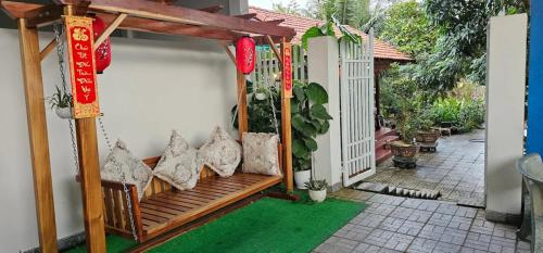a porch with a wooden bench with chinese decorations at Khách sạn 25 tháng 12 - Tánh Linh in Tánh Linh