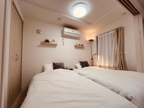 Un dormitorio con dos camas y una ventana. en Raffine103, en Sapporo