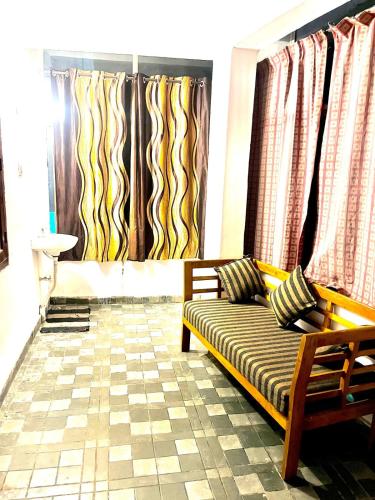 a living room with a couch and some curtains at GlenBrook HomeStay in Munnar