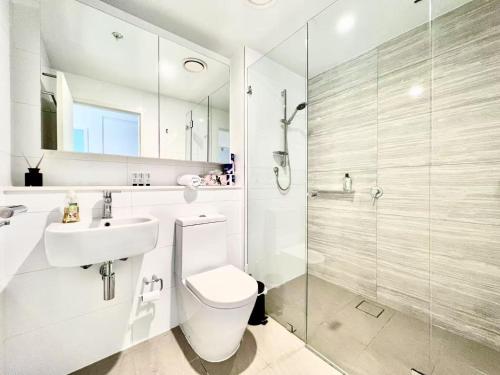 a bathroom with a toilet and a sink and a shower at Modern Comfort Hurstville 1BR Wifi Train Business in Sydney