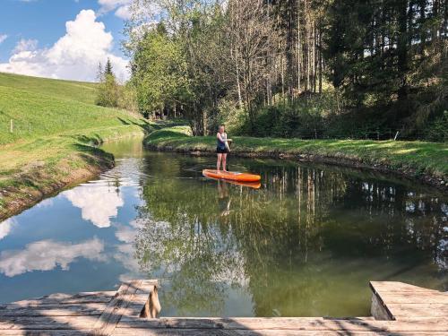 a person standing on a kayak in a river at Mein Landhaus I Die Bachklanghütte in Sankt Veit in der Gegend