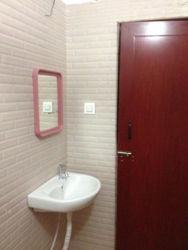 a bathroom with a sink and a red door at GlenBrook HomeStay in Munnar