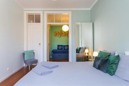 a bedroom with a white bed and a blue couch at Spacious, Bright and Newly Renovated 2 Bedroom Apartment, Lisbon Historical Center, Madragoa in Lisbon