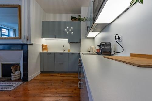 a kitchen with gray cabinets and a fireplace at Le Contemporain - Charme et élégance in Montauban