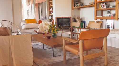un salon avec un canapé et une table avec des chaises dans l'établissement Maison de charme dans les Dentelles de Montmirail, à Suzette