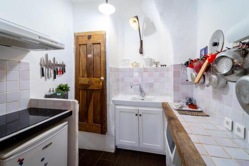a kitchen with a sink and a wooden door at Le petit carnot in Apt