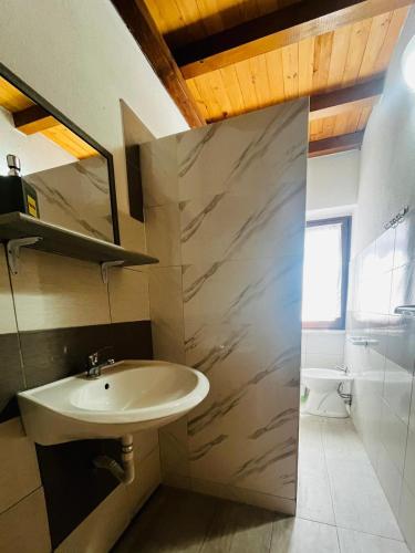 a bathroom with a sink and a mirror and a toilet at The square in Orosei