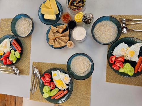 a table topped with plates of food with eggs and vegetables at Kyzyl Say Eco Lodge in Kaji-Say