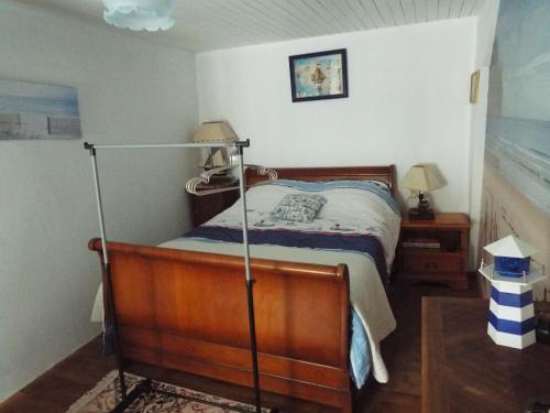 ein Schlafzimmer mit einem Bett mit einer Stange in der Unterkunft maison gite 6 pièces tourisme in Loyat