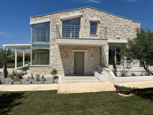 a stone house with a door in a yard at Nikiti Dream Villas in Nikiti