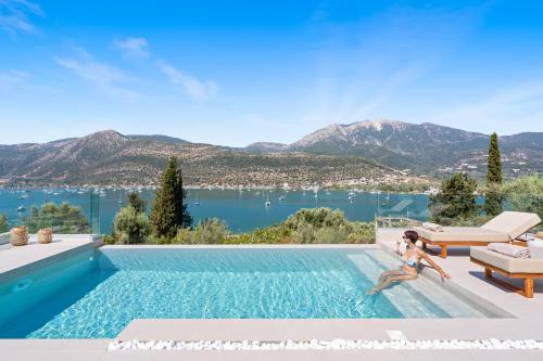 a woman sitting in a swimming pool with a view of the water at Villa Olea in Yenion