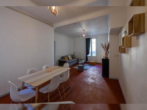 un salon avec une table et des chaises blanches dans l'établissement Grand appartement de 100M2 -Allée Paul Riquet Béziers - 4chambres - Wifi- Tv connectée, à Béziers
