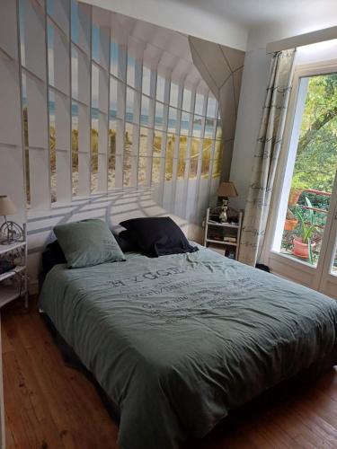 une chambre avec un grand lit et une grande fenêtre dans l'établissement logement privé centre Hossegor jardin parking, à Soorts-Hossegor