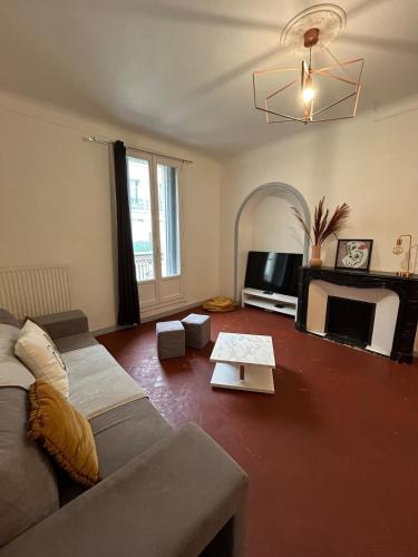 un salon avec un canapé et une cheminée dans l'établissement Grand appartement de 100M2 -Allée Paul Riquet Béziers - 4chambres - Wifi- Tv connectée, à Béziers