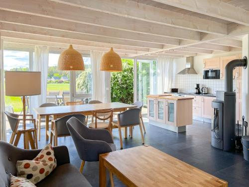 a kitchen and dining room with a table and chairs at Ferienhaus Wiesengeflüster S1 - mit Sauna, Kamin und Workation an der Müritz in Marienfelde