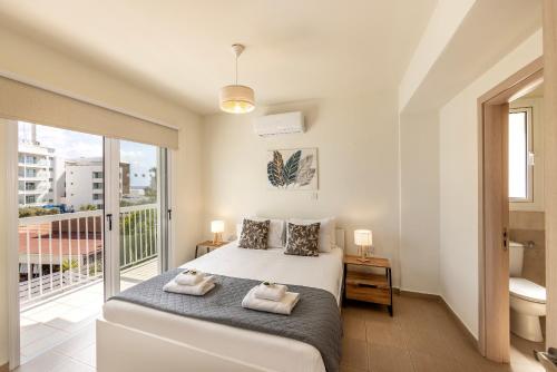 a bedroom with a bed and a balcony at Protaras Villa Cemelia in Protaras