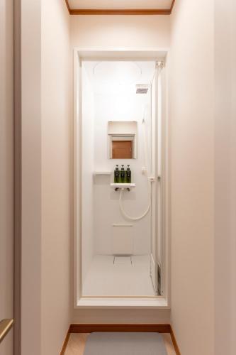 a bathroom with a shower with a mirror at Fantasy Lodge in Tokyo