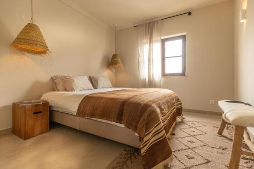 a bedroom with a bed and a window at Vila Laura in Porto Covo