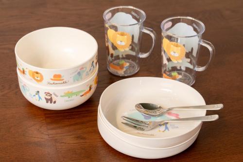 a table with a bowl and a plate and two glasses at Fantasy Lodge in Tokyo
