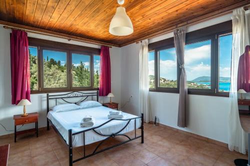 una camera con letto e ampie finestre di Villa Hra Lefkada a Nikiana