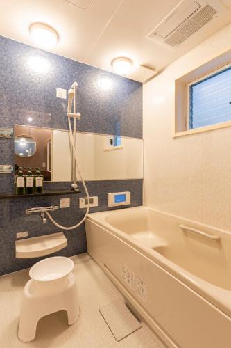 a bathroom with a tub and a toilet and a sink at Fantasy Lodge in Tokyo