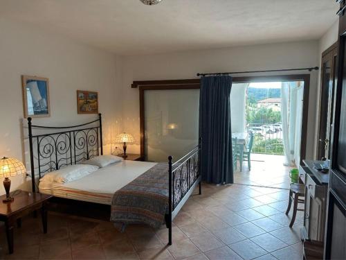 a bedroom with a bed and a balcony at Appartamenti dolores castle in Marina di Campo Airport