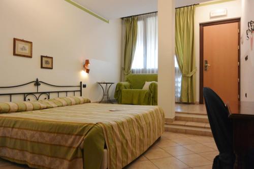a hotel room with a bed and a chair at Hotel Ristorante Italia in Certosa di Pavia