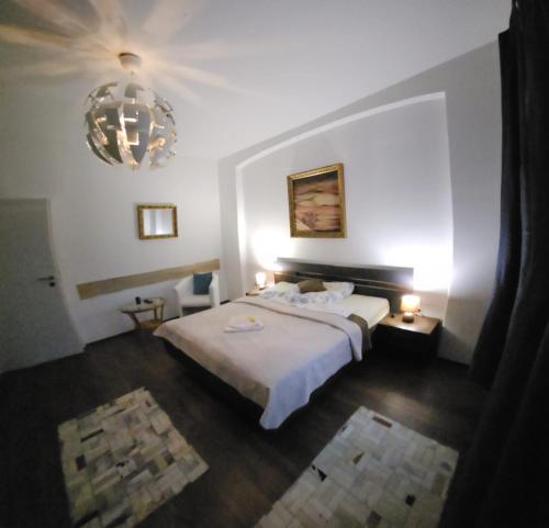 a bedroom with a bed and a chandelier at Bluestars Home in Karlovy Vary