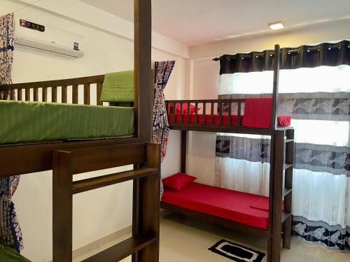 a room with two bunk beds and a window at Curly Hostel Negombo in Negombo