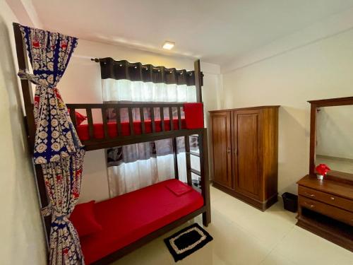 a bedroom with a bunk bed with a red seat at Curly Hostel Negombo in Negombo