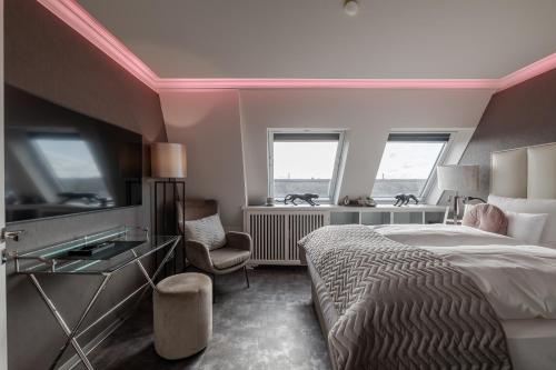 a bedroom with a bed and a desk and two windows at Strönhof Kampen in Kampen