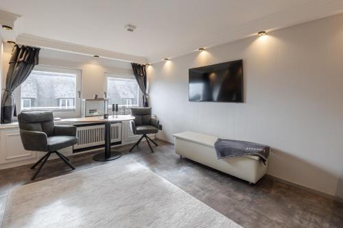 a living room with a desk and two chairs at Strönhof Kampen in Kampen
