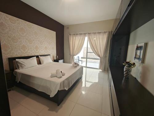 a bedroom with a bed with two towels on it at Modern Luxe Marsaskala Maisonette in Marsaskala