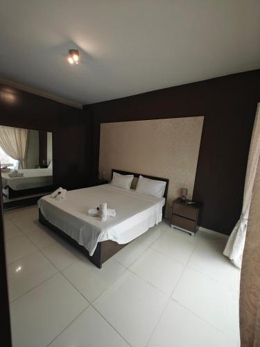 a bedroom with a white bed with a black wall at Modern Luxe Marsaskala Maisonette in Marsaskala