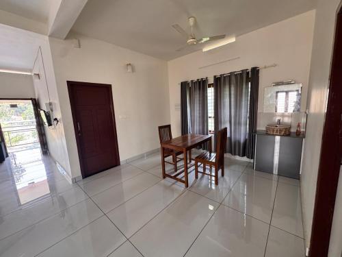 a dining room with a table and chairs in a room at Sree Shivanya Homes in Trivandrum