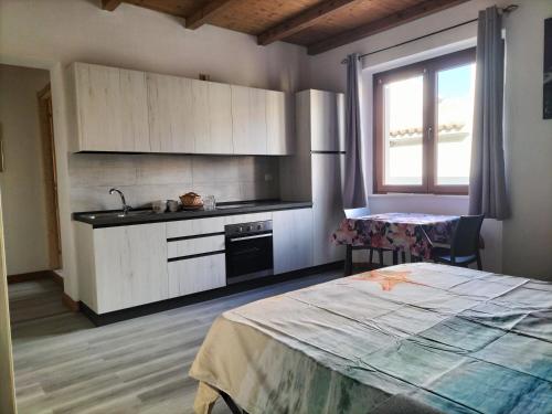 a kitchen with a bed and a sink in a room at The square in Orosei