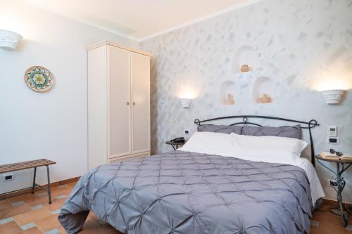 a bedroom with a bed and a white wall at Il Marchese Hotel & Spa in Sciacca