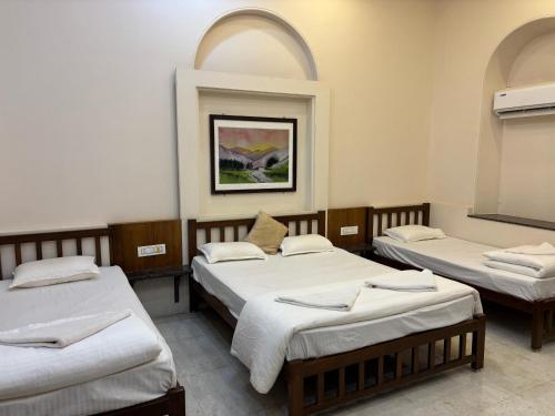a room with three beds and two arched windows at Madhuvan Retreat Resort Amba in Chandoli