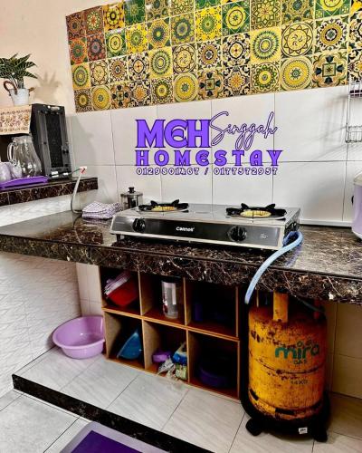 a kitchen with a counter with a counter top with a counter top at MEH Singgah Homestay, Sungai Udang in Kampong Alor