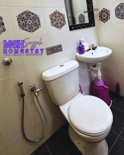 a bathroom with a toilet and a sink at MEH Singgah Homestay, Sungai Udang in Kampong Alor