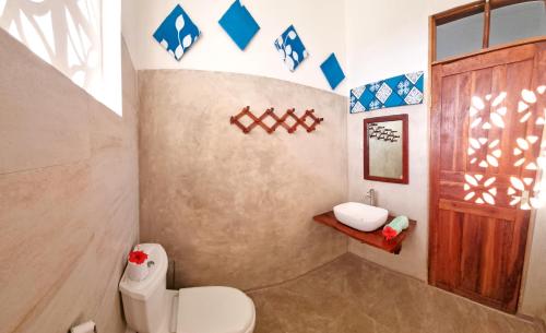 a bathroom with a toilet and a sink at Paje Cozy Apartments in Paje