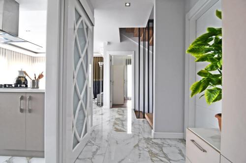 einen Flur mit weißen Wänden und Marmorböden in der Unterkunft Golden Life Family Villa 2 in Dosemealti