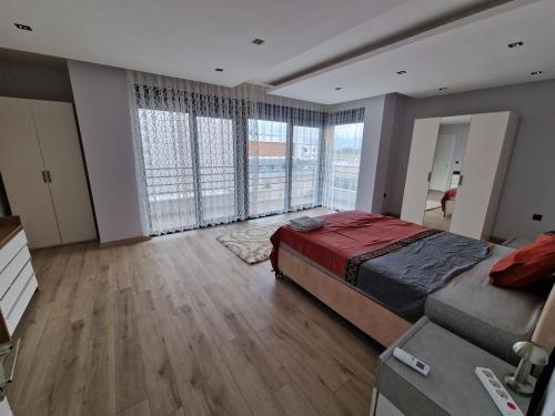 ein Schlafzimmer mit großem Bett und großen Fenstern in der Unterkunft Golden Life Family Villa 2 in Dosemealti