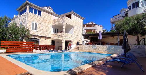a swimming pool in front of a house at Villa Marijeta Hvar in Hvar