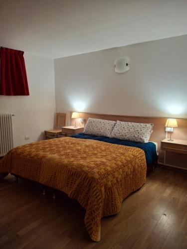 a bedroom with a bed and two tables and two lamps at Bellavista Home with pool & lakeview in Plesio
