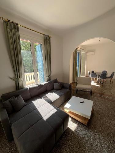 een woonkamer met een bank en een tafel bij Seaside Jungle Retreat in Nice