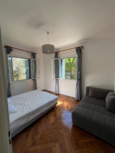 - une chambre avec un lit, un canapé et deux fenêtres dans l'établissement Seaside Jungle Retreat, à Nice